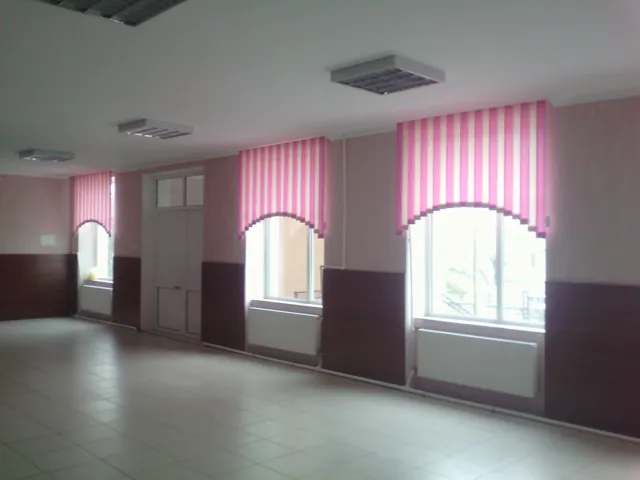 Jaluzele verticale decorative roz într-o sală spațioasă