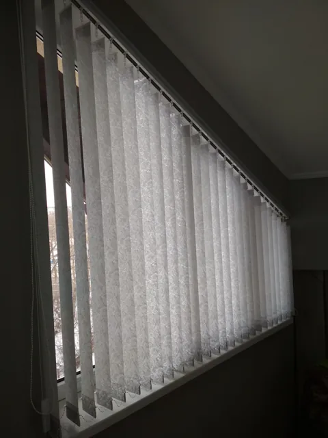 Jaluzele verticale pe un șir lung de ferestre
