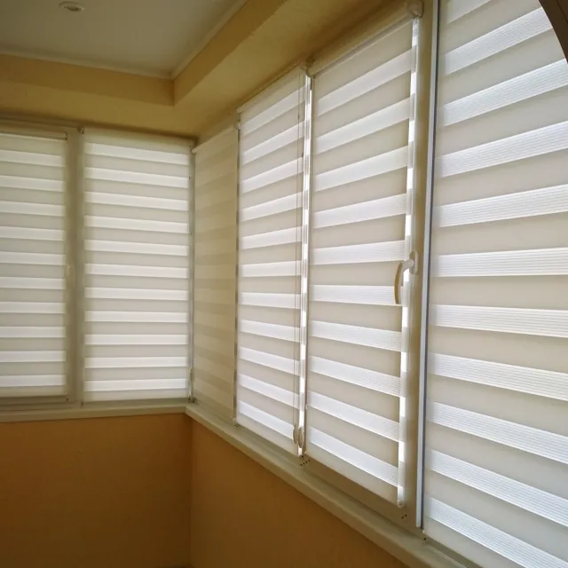 Jaluzele Zi-Noapte crem pe ferestrele unui balcon