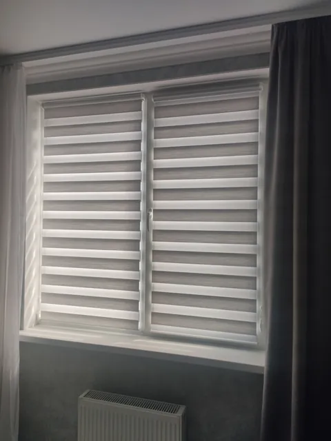 Jaluzele Zi-Noapte albe, lângă o draperie gri
